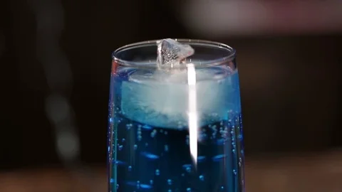 A glass of blue cold drink, floating polar bear-shaped ice Stock Footage 71025279