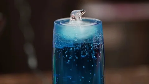 A glass of blue cold drink, floating polar bear-shaped ice Stock Footage 71025503