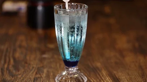 A glass of blue cold drink, floating polar bear-shaped ice Stock Footage 71025736