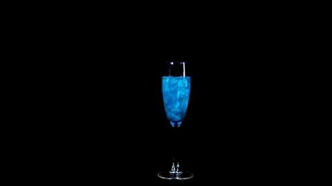 Glass with blue liquid. The elixir spins and overflows with liquid. Potion of Stock Footage 123087381