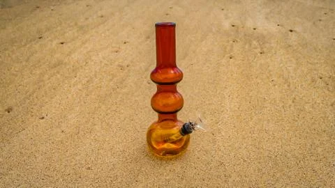 Glass bong on the sand Stock Photos