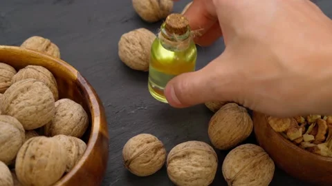 Glass bottle with essence, raw walnut peeled and in their shells, rustic style Stock Footage 199197486