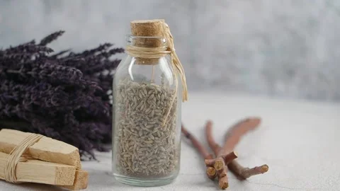 Glass Bottle Filled With Dried Lavender Buds and Palo Santo Sticks Stock Footage 346738697