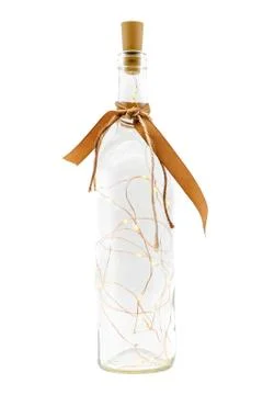 A glass bottle filled with a led string of lights and a bow on the bottle nec Stock Photos