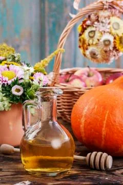 Glass bottle of honey and ripe pumpkins on the table. Stock Photos