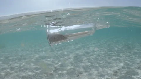 Glass bottle with message floats in transparent water of sea or ocean. Stock Footage 150537325