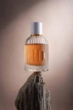 Glass bottle standing on a stone. Dramatic light creative photography for per Stock Photos
