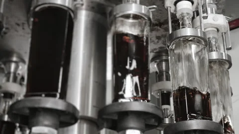 Glass bottles are automatically filled with liquid. Stock Footage 284496932
