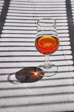 Glass of brandy on concrete surface Foto stock