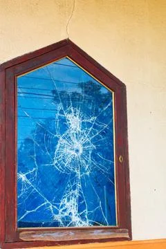 Glass broken into a thousand pieces by a bullet impact Stock Photos