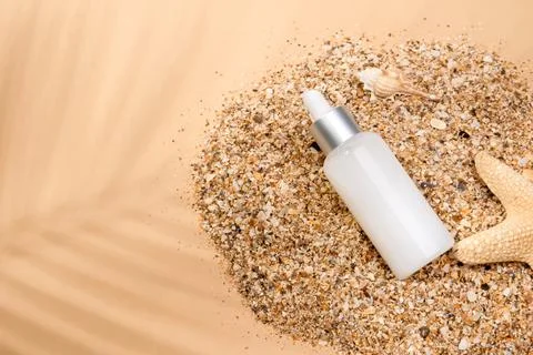 Glass brown bottle with a pipette on the sand Stock Photos