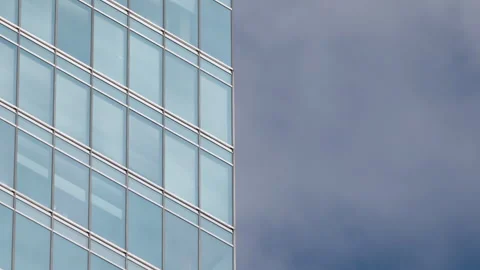 Glass building windows showing cloud reflections in sky, modern skyscraper Vídeo Stock 333651590