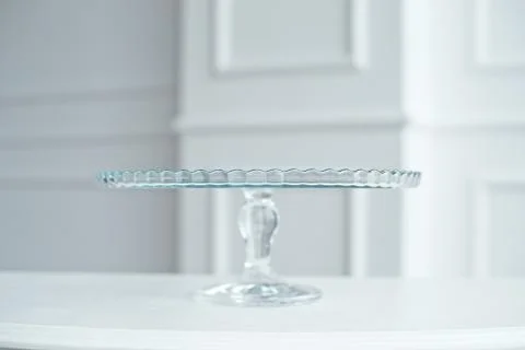 Glass cake stand on white table isolated on white background. Stock Photos