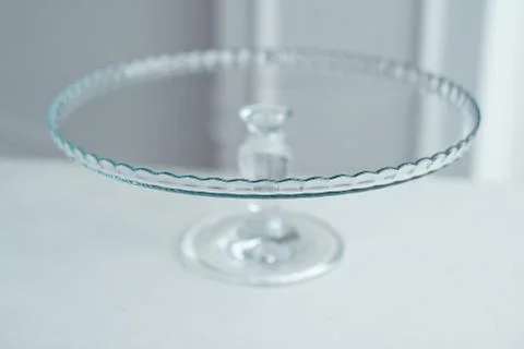 Glass cake stand on white table isolated on white background. Stock Photos