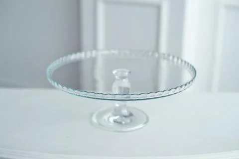 Glass cake stand on white table isolated on white background. Stock Photos