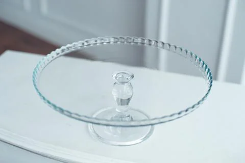Glass cake stand on white table isolated on white background. Stock Photos
