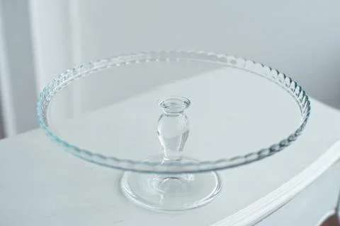 Glass cake stand on white table isolated on white background. Stock Photos