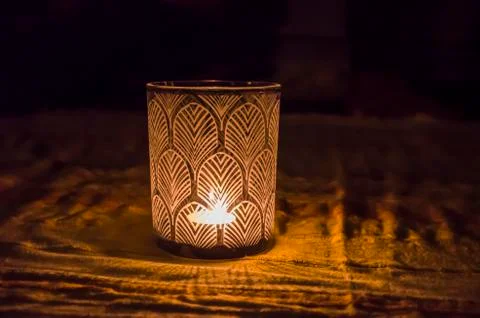 Glass candlestick patterned glowing in the dark . Stock Photos