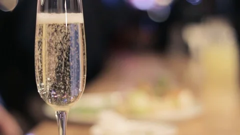 A glass of champagne on a blurred background Stock Footage 103049771
