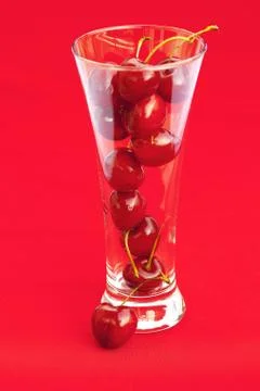 Glass of cherry  on a red background Stock Photos