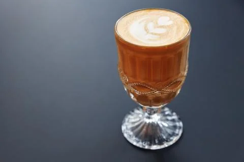 Glass of coffee with foam with a pattern on a gray background Stock Photos