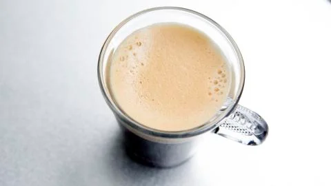 Glass with coffee on silver background 스톡 사진