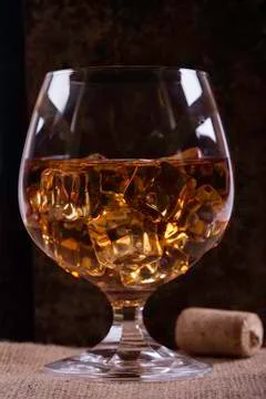 Glass of cognac with ice closeup background Stock Photos