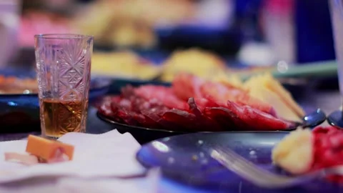 A glass of cognac stands on the table against the background of various dishes Stock Footage 264771604