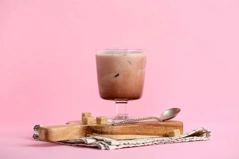 Glass of cold cocoa drink and cubes of sugar on pink background Stock Photos