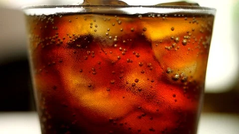 Glass of cold cola with ice cubes shot in slow motion Stock Footage 114264311