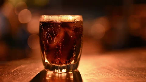 Glass with cold drink and ice cubes on table, Frosted coca cola in cup Stock Footage 237608900