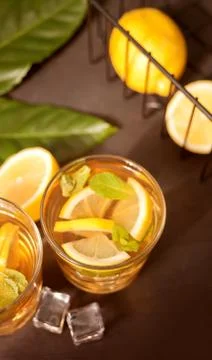 Glass of cold refreshment tea with ice and lemon fruit. Stock Photos