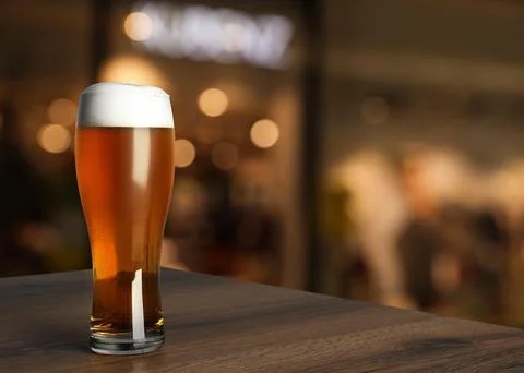 Glass with cold tasty beer on wooden table in pub, space for text Stock Photos