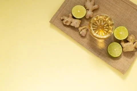 Glass of cold tea with three lemon slices and pieces of ginger on a blue back Stock Photos