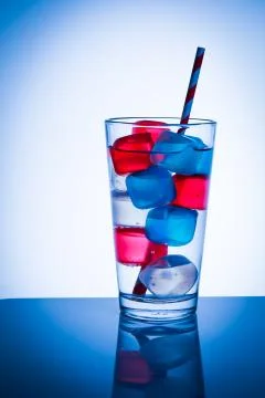 Glass with colored cubes Stock Photos