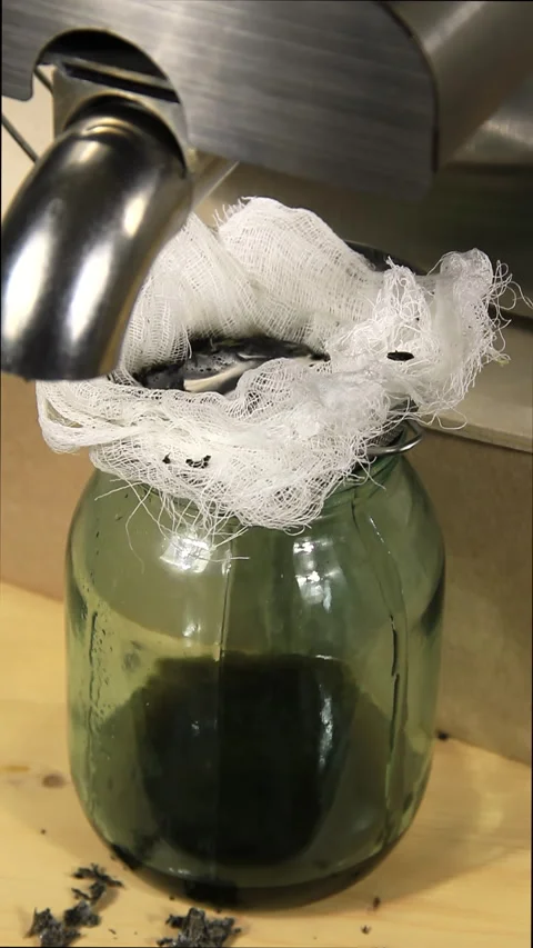 A glass container accepting pressed vegetable oil. Stock Footage 168888889