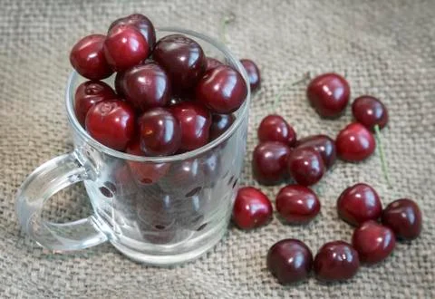 Glass Cup with cherries on the table. Stock Photos