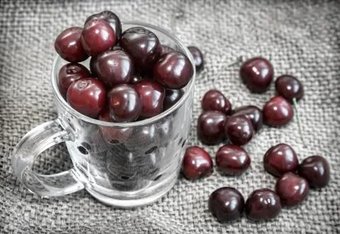 Glass Cup with cherries on the table. Stock Photos