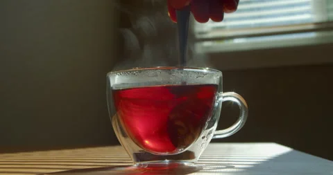 Glass cup with hot tea on the kitchen table on a sunny day. Stock Footage 231707641