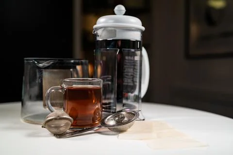 Glass cup mug of fresh warm tasty Ceylon black tea with french press, teapot Stock Photos