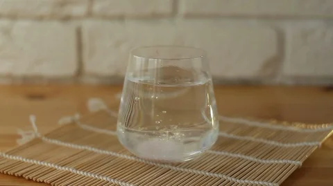 Glass cup on  table with effervescent vitamins Vidéo 129346008
