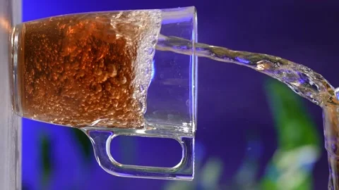 Glass cup of tea, black tea bag dissolves in hot water. Stock Footage 238916932