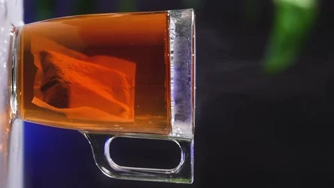 Glass cup of tea, black tea bag dissolves in hot water. Stock Footage 238918705