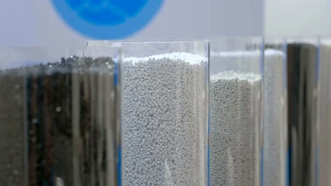 In glass cylinder containers, samples of plastic granules of black and white Stock Footage 187755199