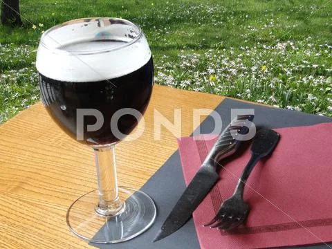 Glass Of Dark Beer On Restaurant Table ..