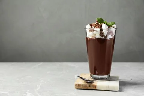 Glass of delicious hot chocolate with marshmallows and fresh mint on light gr Stock Photos