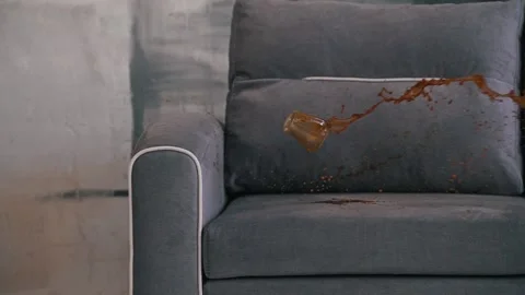 Glass with a drink fell on the sofa close-up Stock Footage 160938701