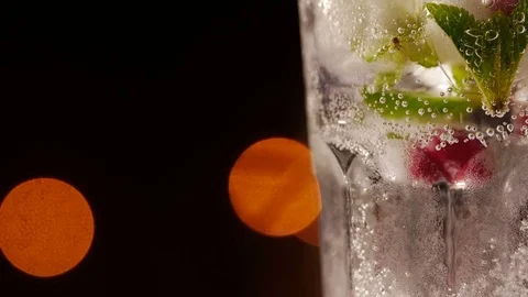 Glass with drink, ice, mint and berries on a blurry background 動画素材 73997969