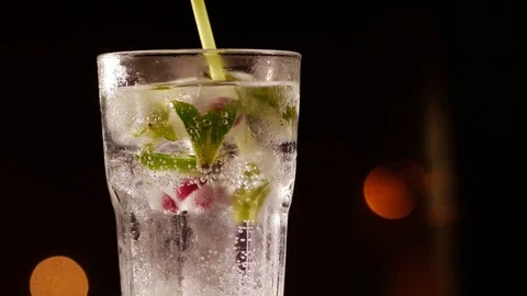 Glass with drink, ice, mint and berries on a blurry background 库存影片 73998041