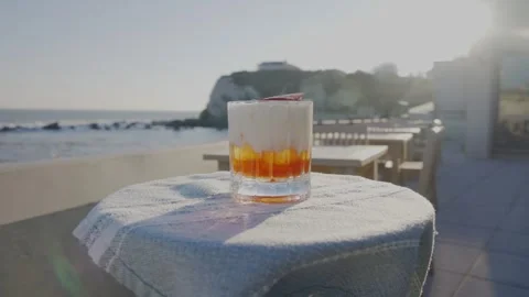 A glass of drink is on a table with a cloth on it Stock Footage 306576006